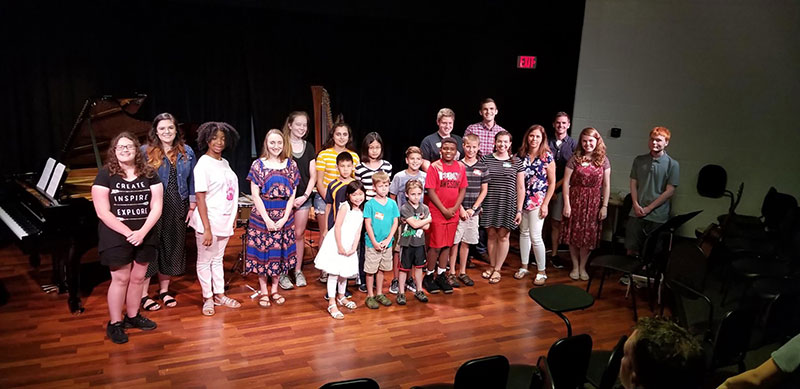 teachers stand with students on stage