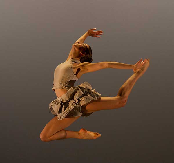 dancer jumping arms extended and head back