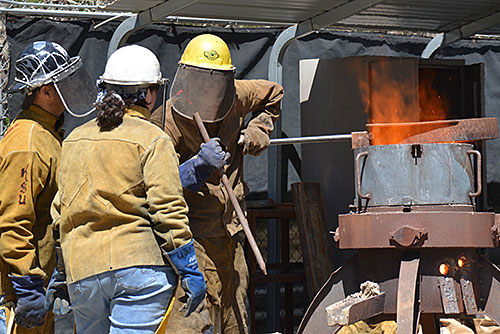 art students in protective gear for pouring molten iron