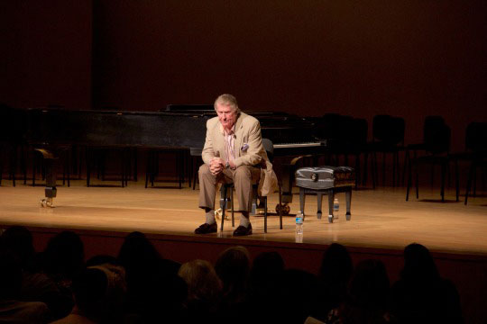 Sherrill Milnes sitting on stage listening to student