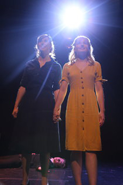 two girls holding hands with bright light