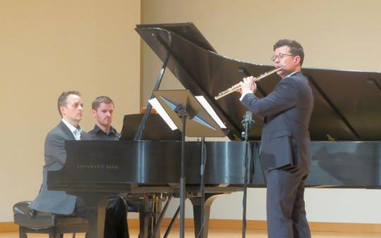 pianist and flutist performing on stage