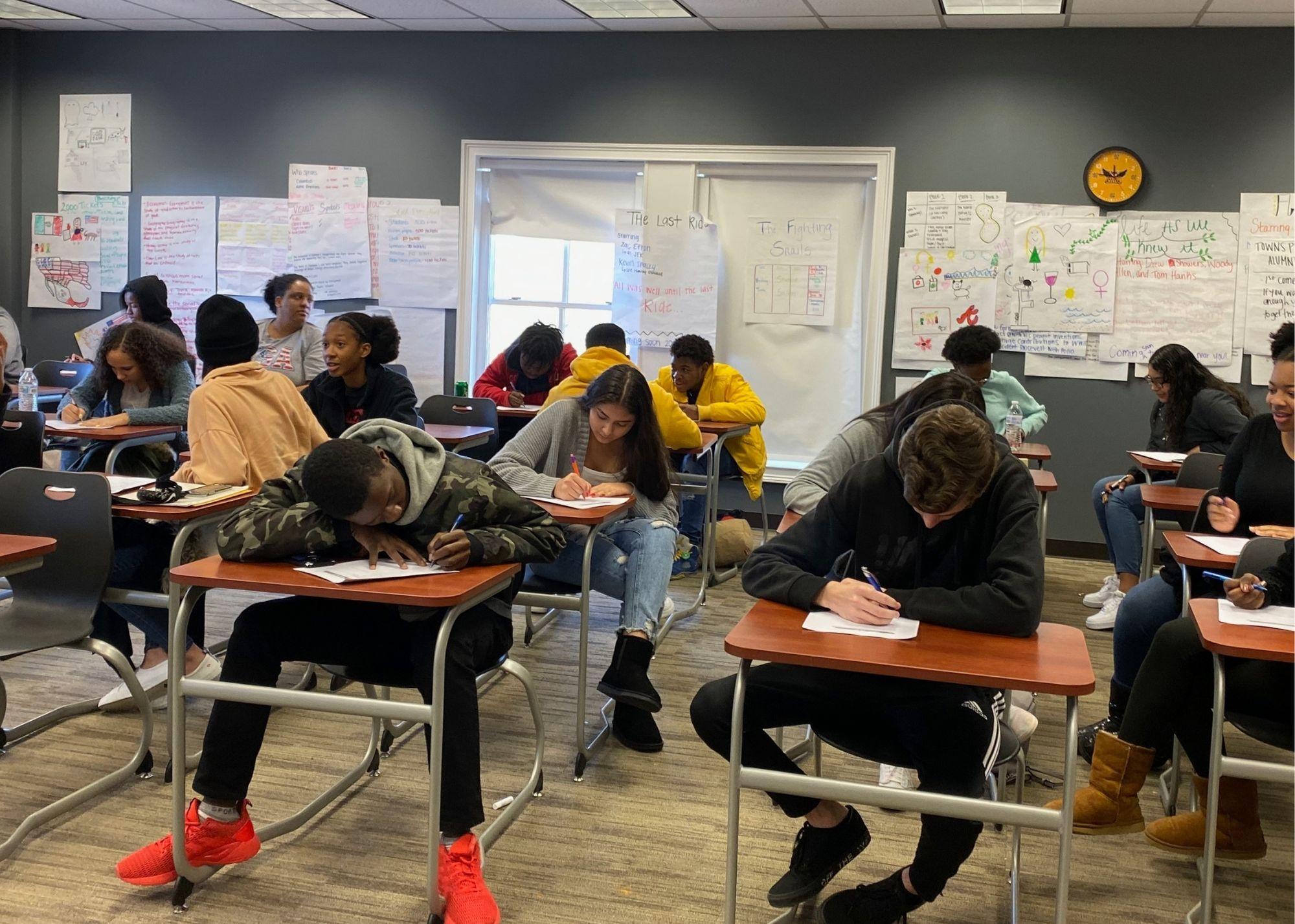 Students sitting at desks taking an exam in a classroom setting / ACT Test Prep Boot Camp that aims to not only prepare high school students for the big test that will determine their college entrance, but they are also working to prepare students for life in the community. The Boot Camp is a 10-week commitment that takes place every Saturday, and students that give up their weekends gain confidence for their ACT Test and learn soft skills that will benefit them in their future workplaces, such as timeliness, work ethic, and accountability.