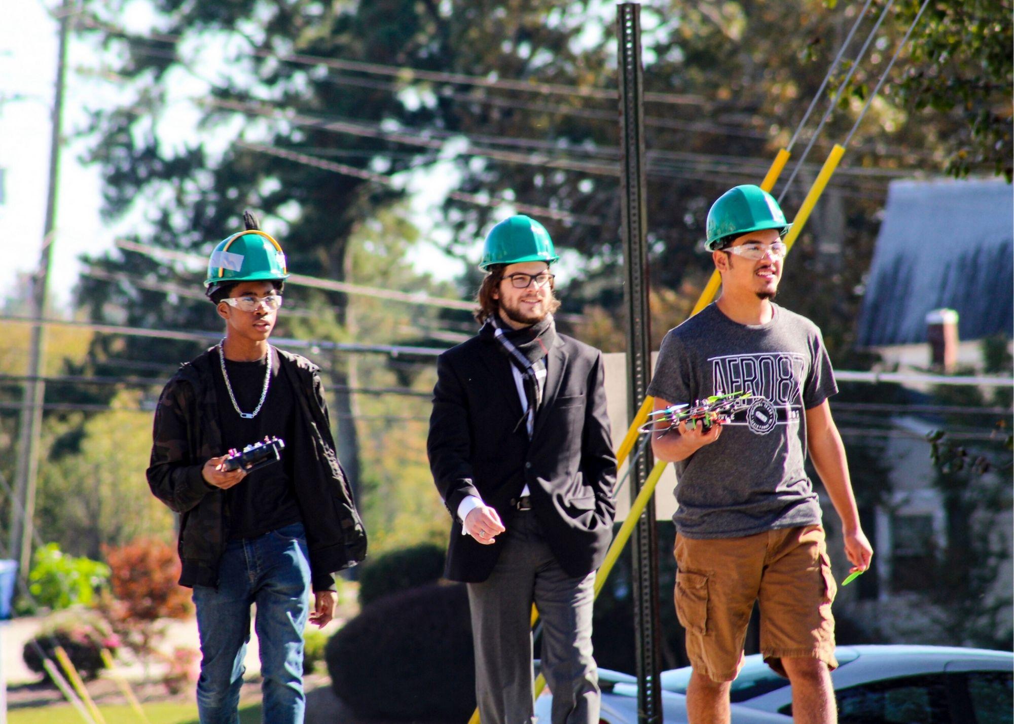 Students wearing hardhats, learning about drone flying / KSU TRIO's groundbreaking Drone Program introduces students to the basics of drone flying, ethics, and mechanics, and the program gives students the opportunity to test for their FAA Pilot's License