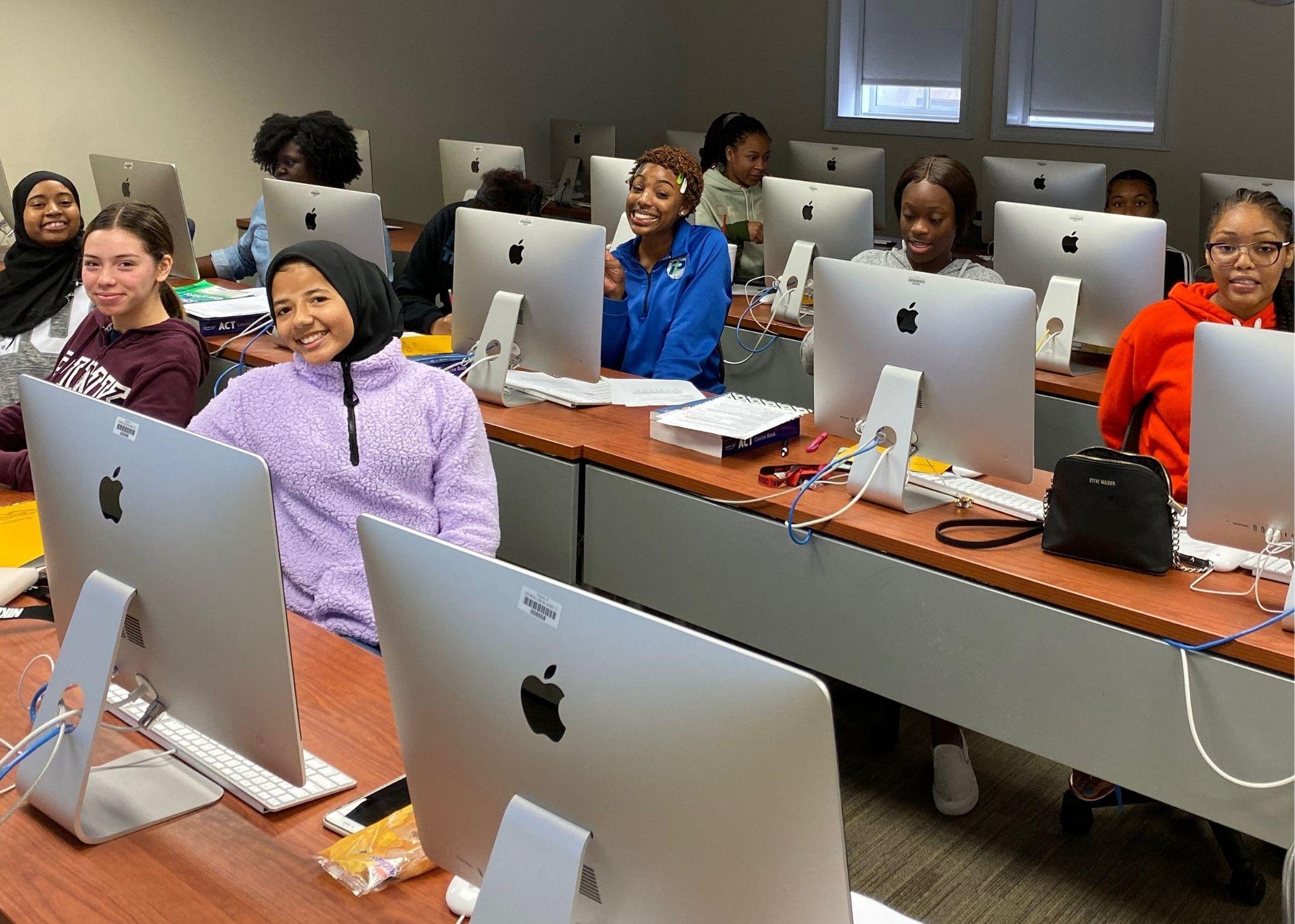 Students sitting in front of desktop computers in a classroom setting / ACT Test Prep Boot Camp that aims to not only prepare high school students for the big test that will determine their college entrance, but they are also working to prepare students for life in the community. The Boot Camp is a 10-week commitment that takes place every Saturday, and students that give up their weekends gain confidence for their ACT Test and learn soft skills that will benefit them in their future workplaces, such as timeliness, work ethic, and accountability.