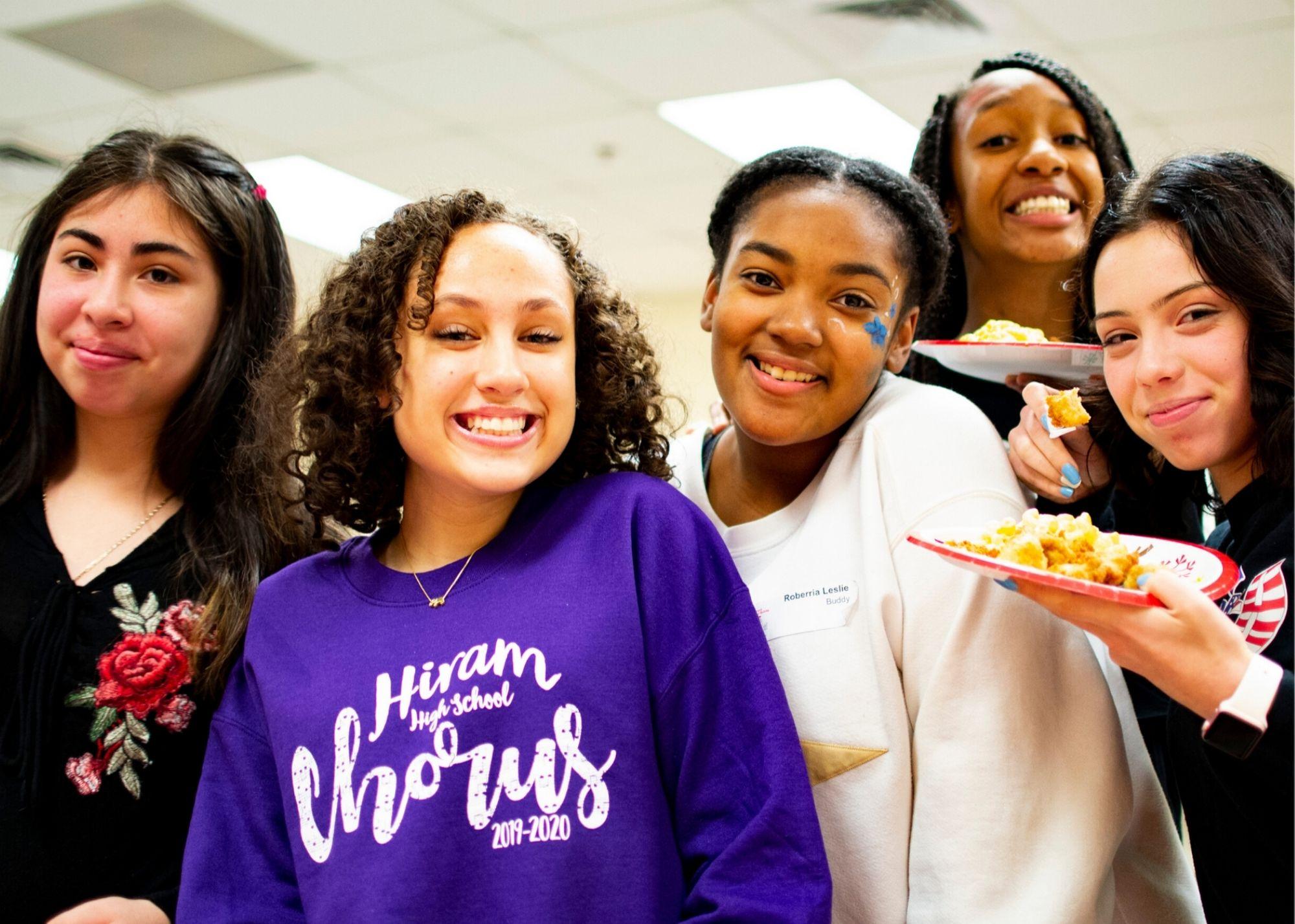 Students smiling and holding plates of food. / Hiram High School Upward Bound celebrates the holidays and learns about college planning