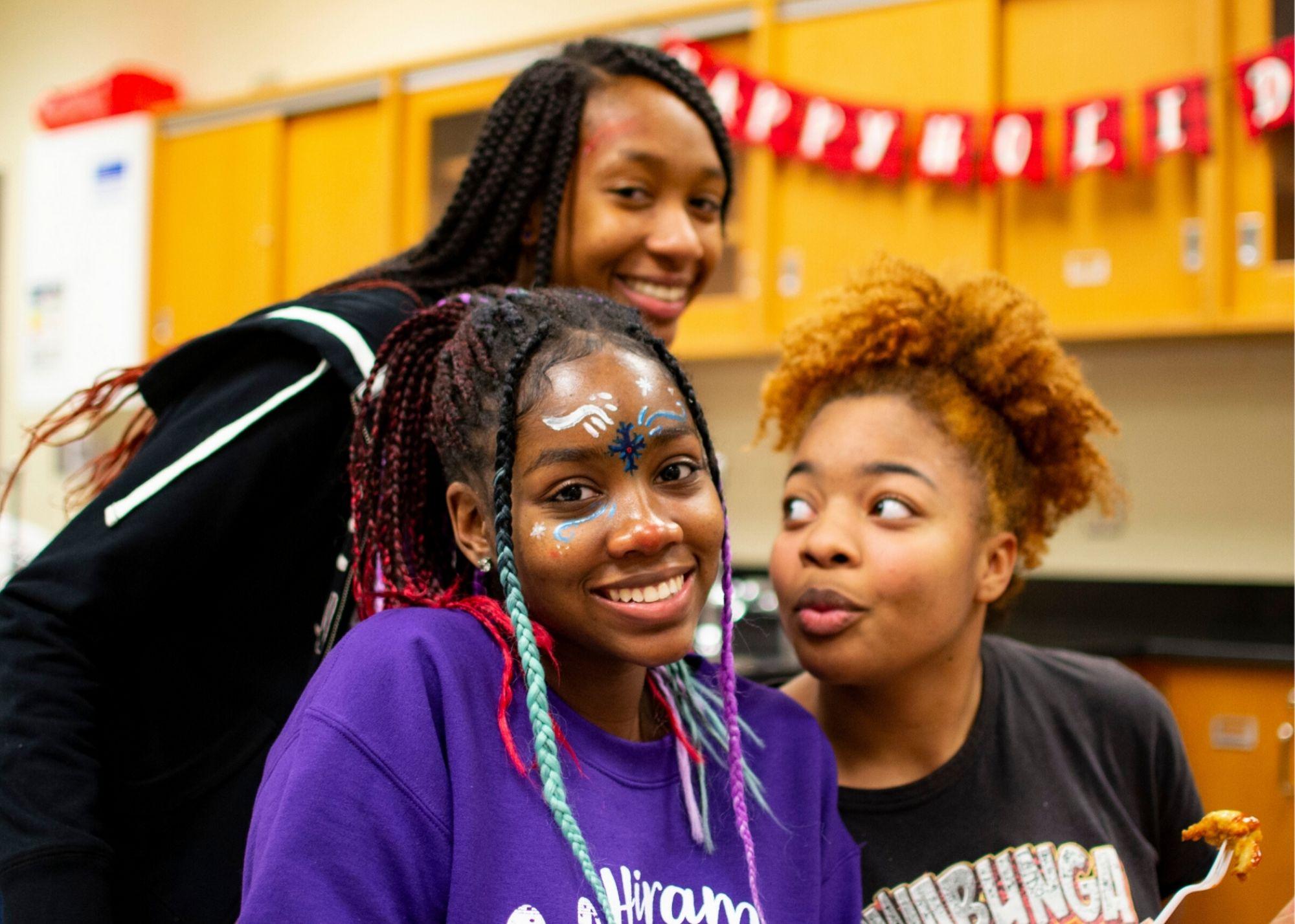 Students smiling with a holiday banner hanging in the background. / Hiram High School Upward Bound celebrates the holidays and learns about college planning