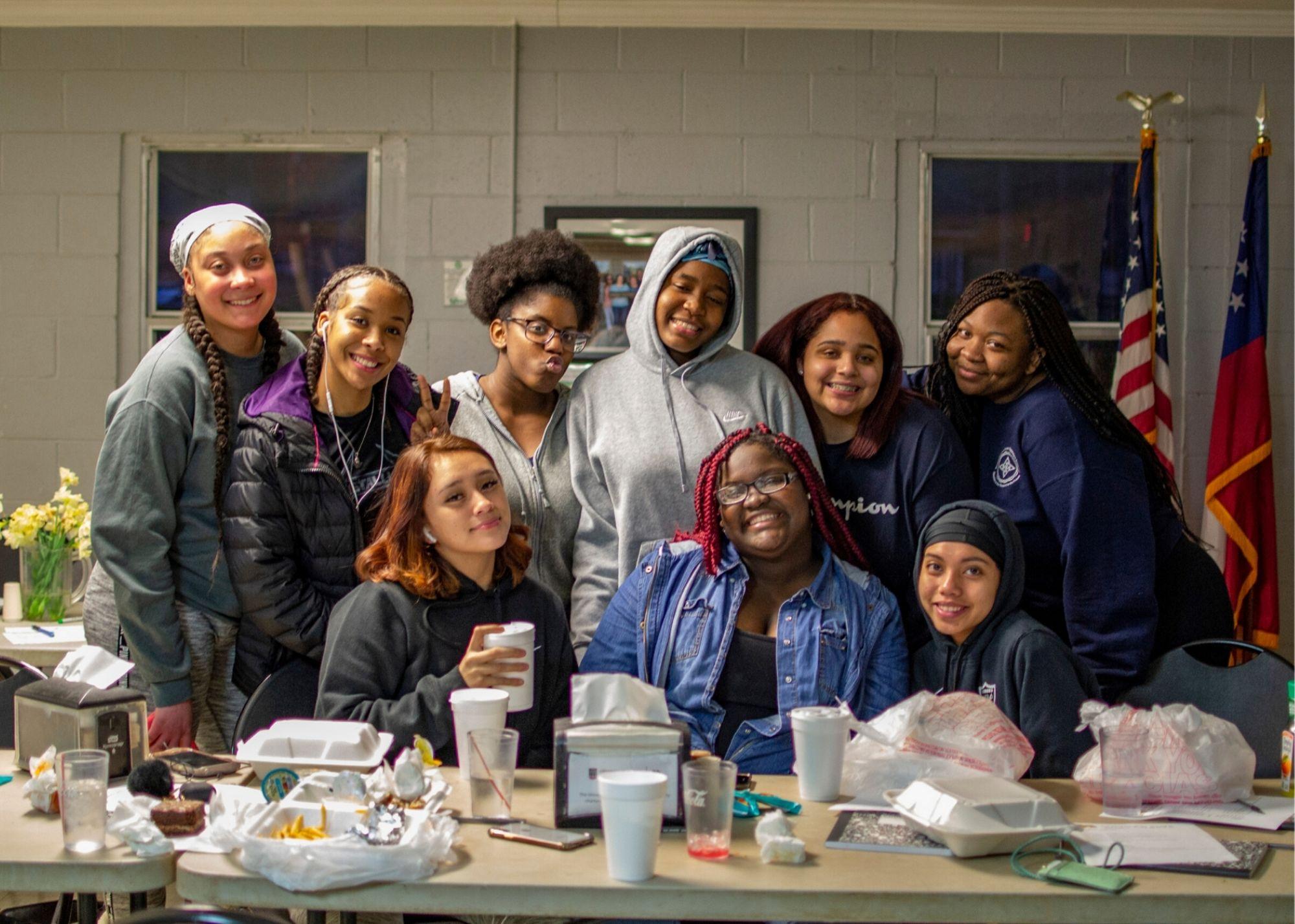 Women smiling in front of a table with food and drinks / KSU TRiO holds a Women's Empowerment Conference to provide a space space for women to learn and grow.