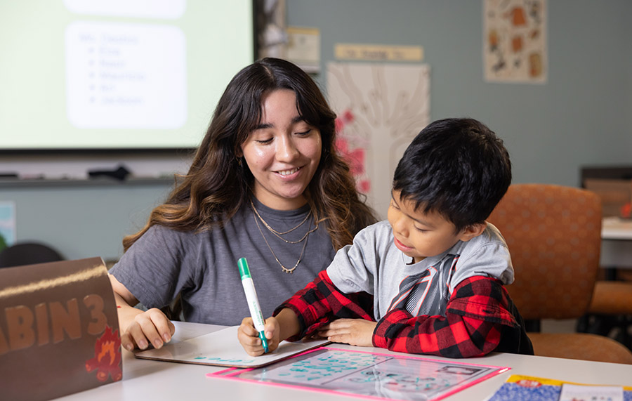 Teacher helping a elementary student with reading