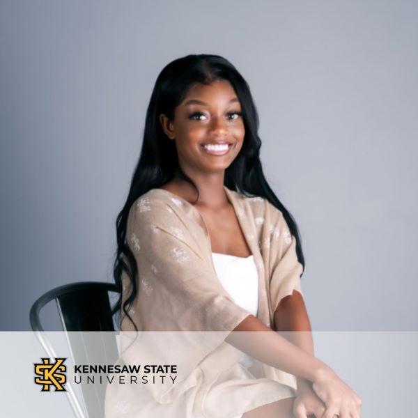 Adah Billington, a smiling student in a neutral background with the Kennesaw State University logo in the bottom corner.