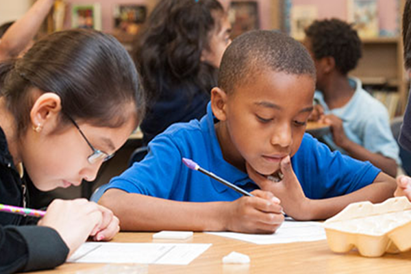 2 elem kids sitting at desk working