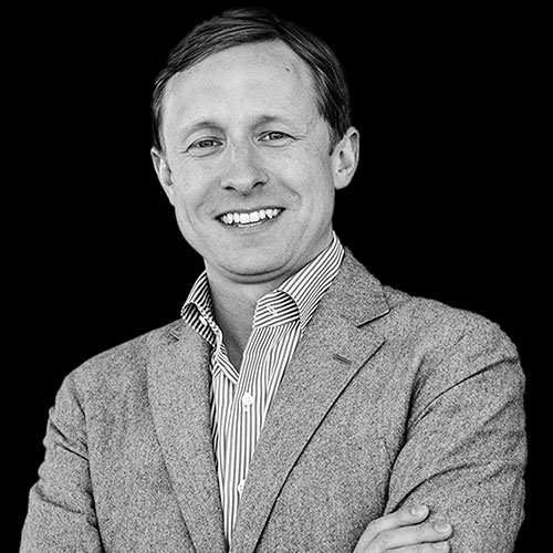 Black and white portrait of Jeff Williams, smiling with arms crossed.