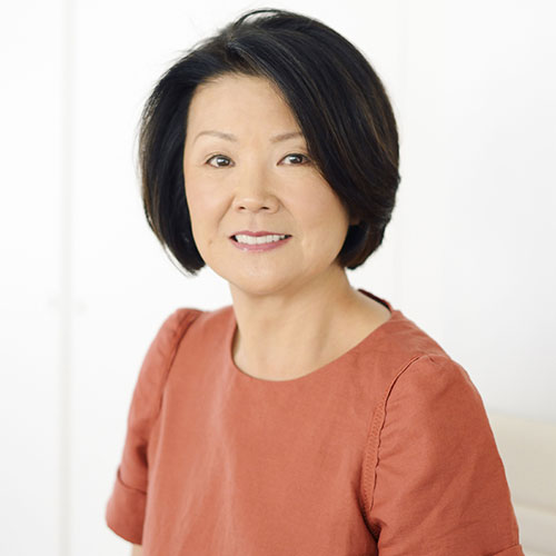 Toshiko Mori headshot, wearing a coral colored top. 