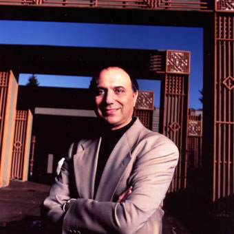 Farouk Noormohamed posing in front of architecture arches. 