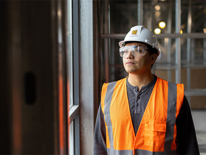 ksu construction management graduate in a hard hat and safety goggles on a site