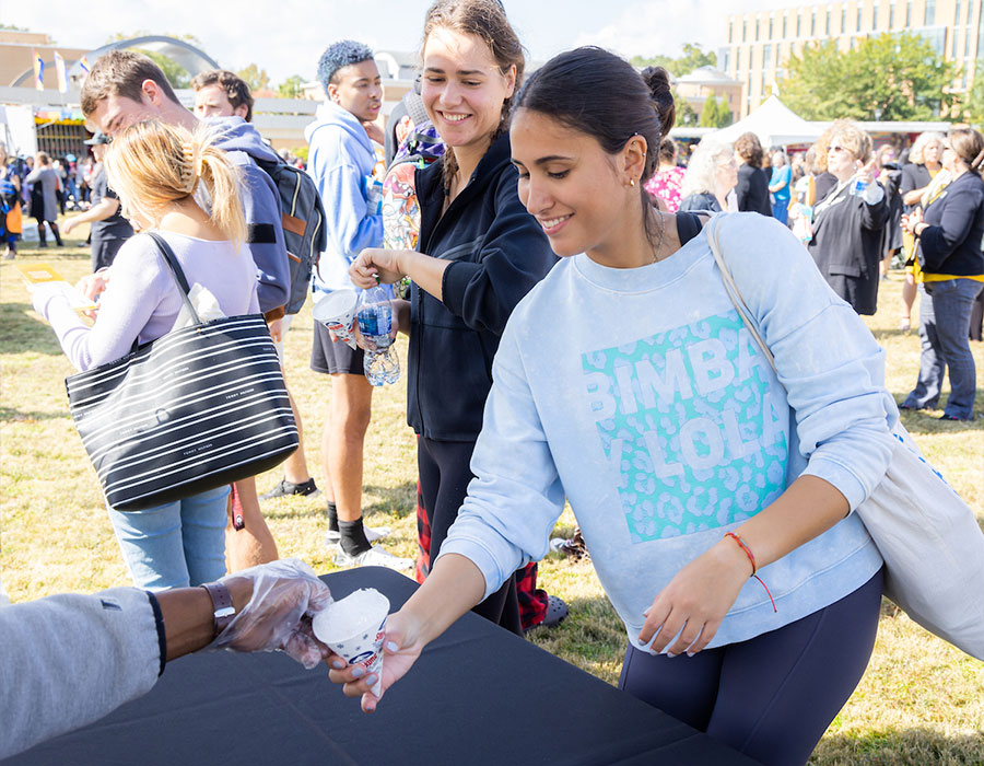 ksu student on the green at a event getting a snow cone