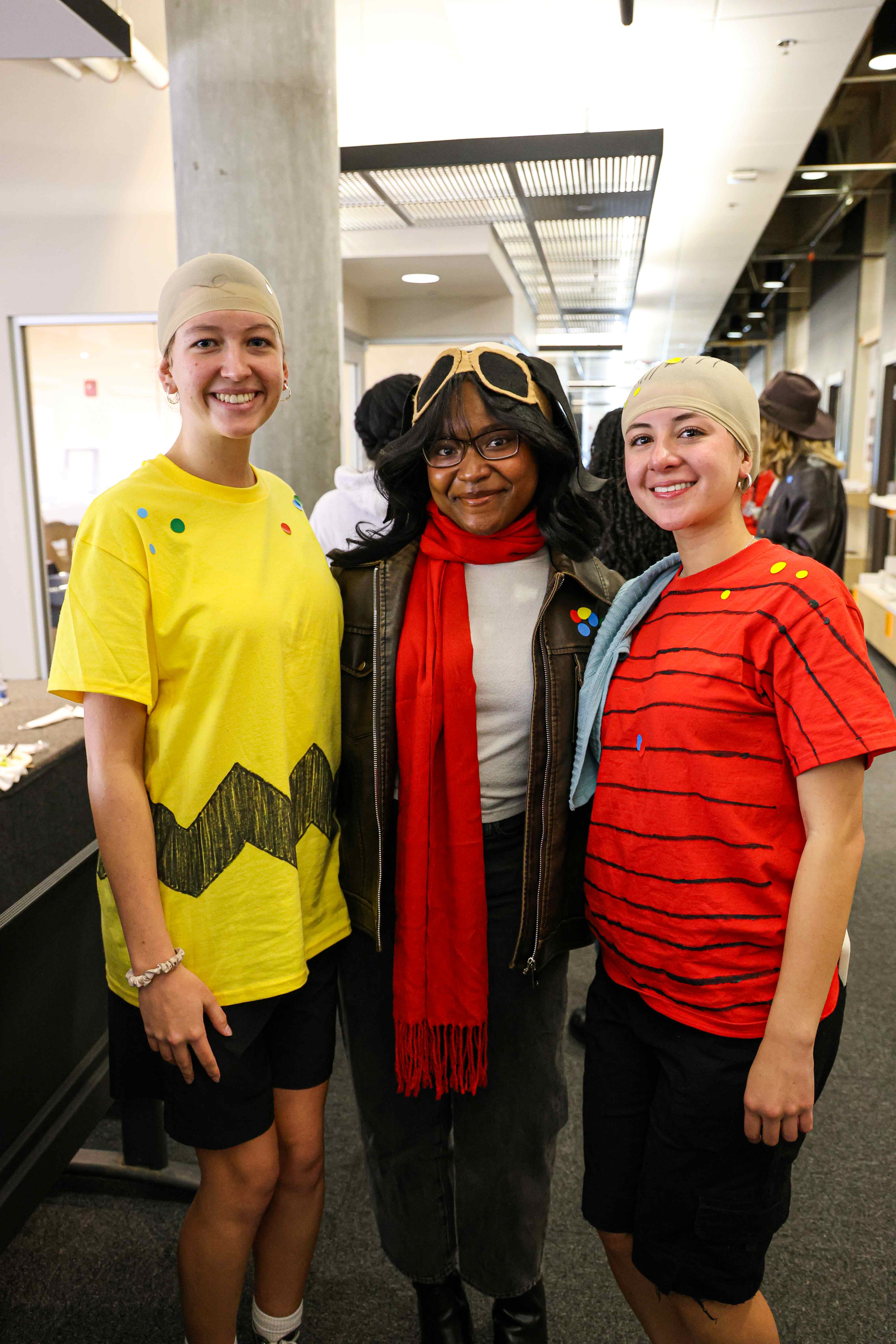 Students in halloween costumes dressed as Charlie Brown, Snoopy, and Linus.