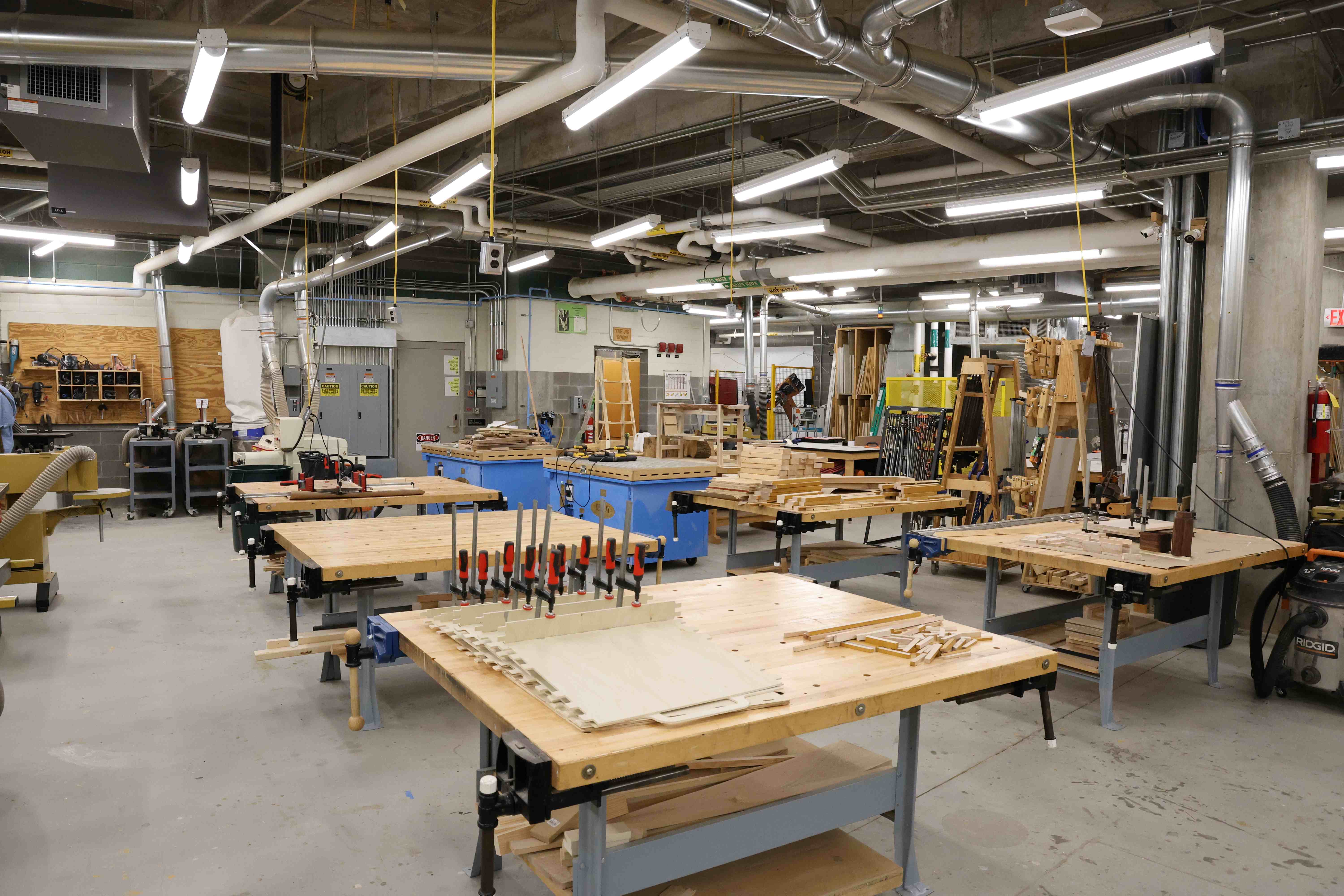 Woodworking tables and tools in a sprawling workshop.