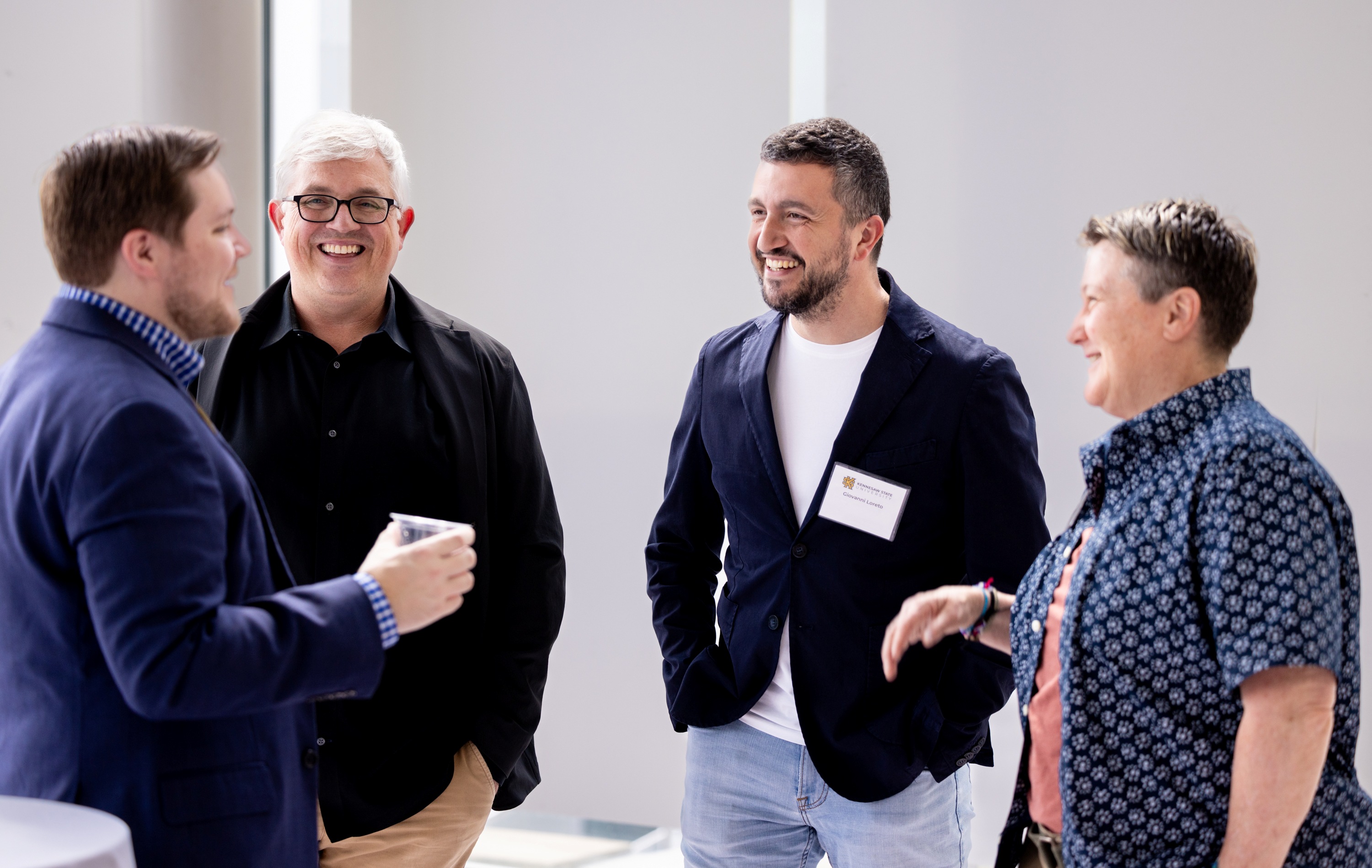 A group of CACM faculty talking and smiling. 
