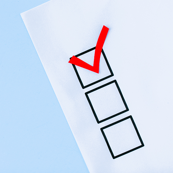checklist with red check mark on blue paper