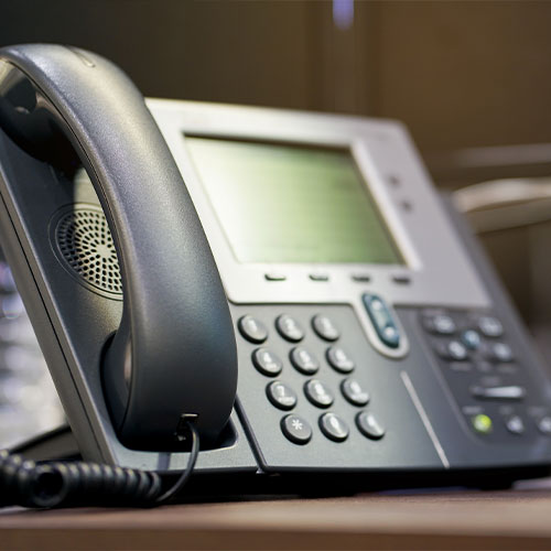 a office phone sitting on a desk.
