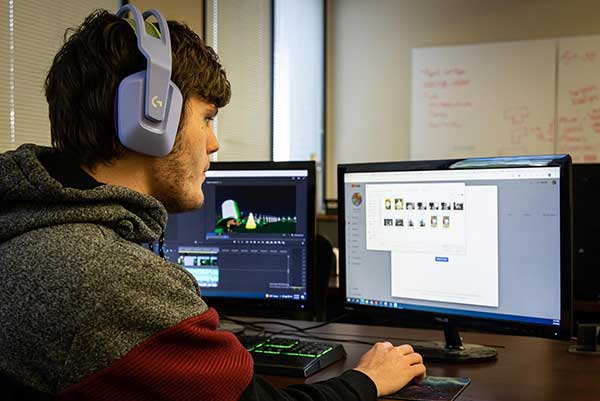 ksu software and game development student working at his dual monitor computer