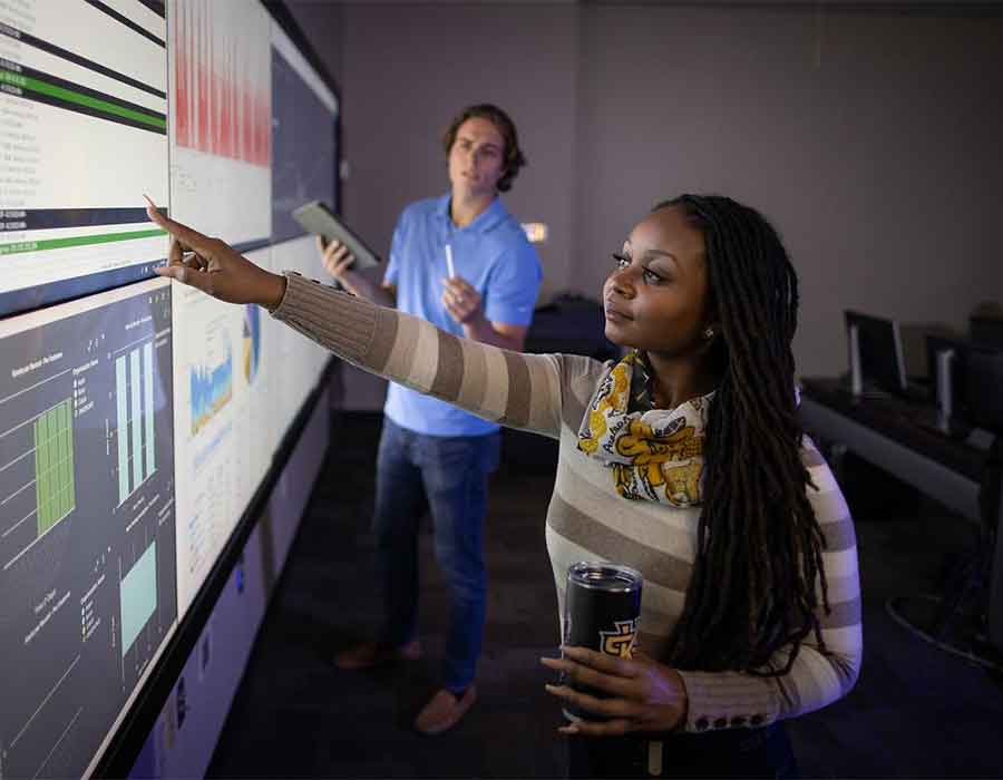 ksu students looking at information technology on touch screen.