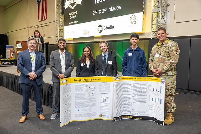 A picture of the second and third place winners for the Undergraduate Research category. Second place is UR-172 A Comparative Study of LLM Effectiveness in Mental Health Assistance by Kris Prasad. Third place is UR-213 Generative AI & Cybersecurity by Seth G Canada and Shreya Katare