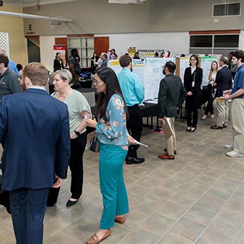 Students gathering around various presentations