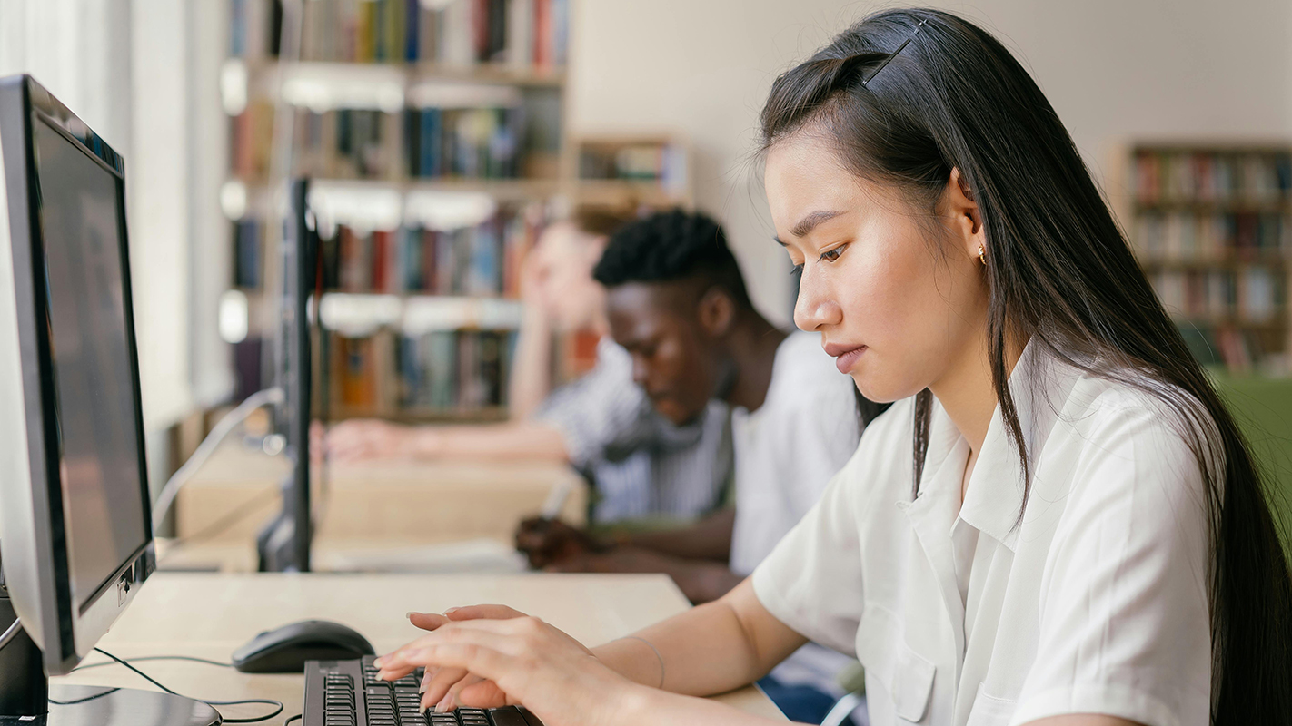 A young computer student works on an assignment.