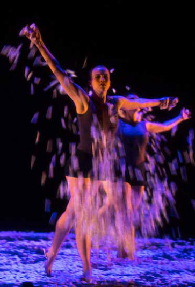 A student dancing with moon dust falling all around her.