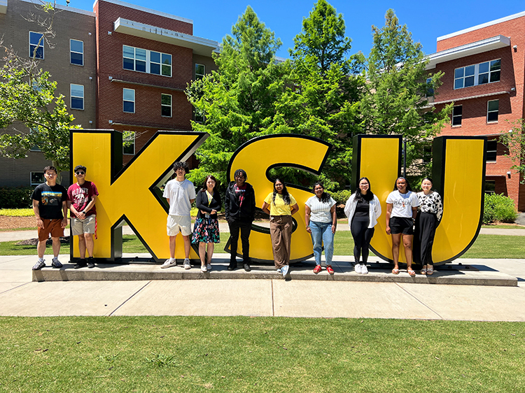 Students gathered around large KSU letters.