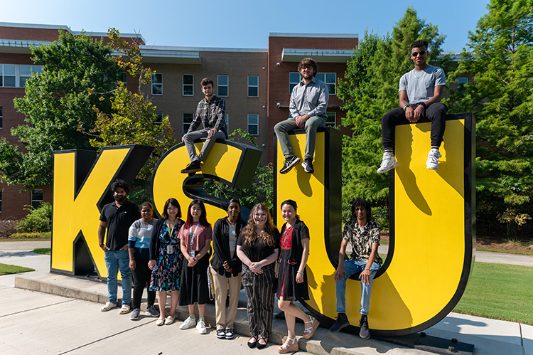 Students gathered around large KSU letters.