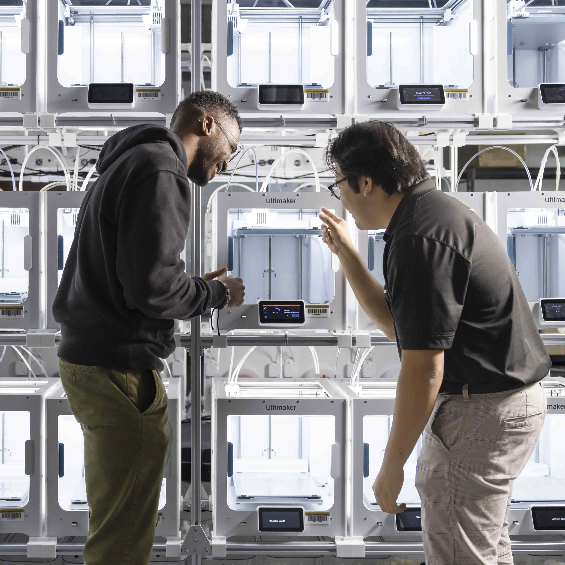 two ksu students in the 3d farm lab looking at utiker lab equipment printer