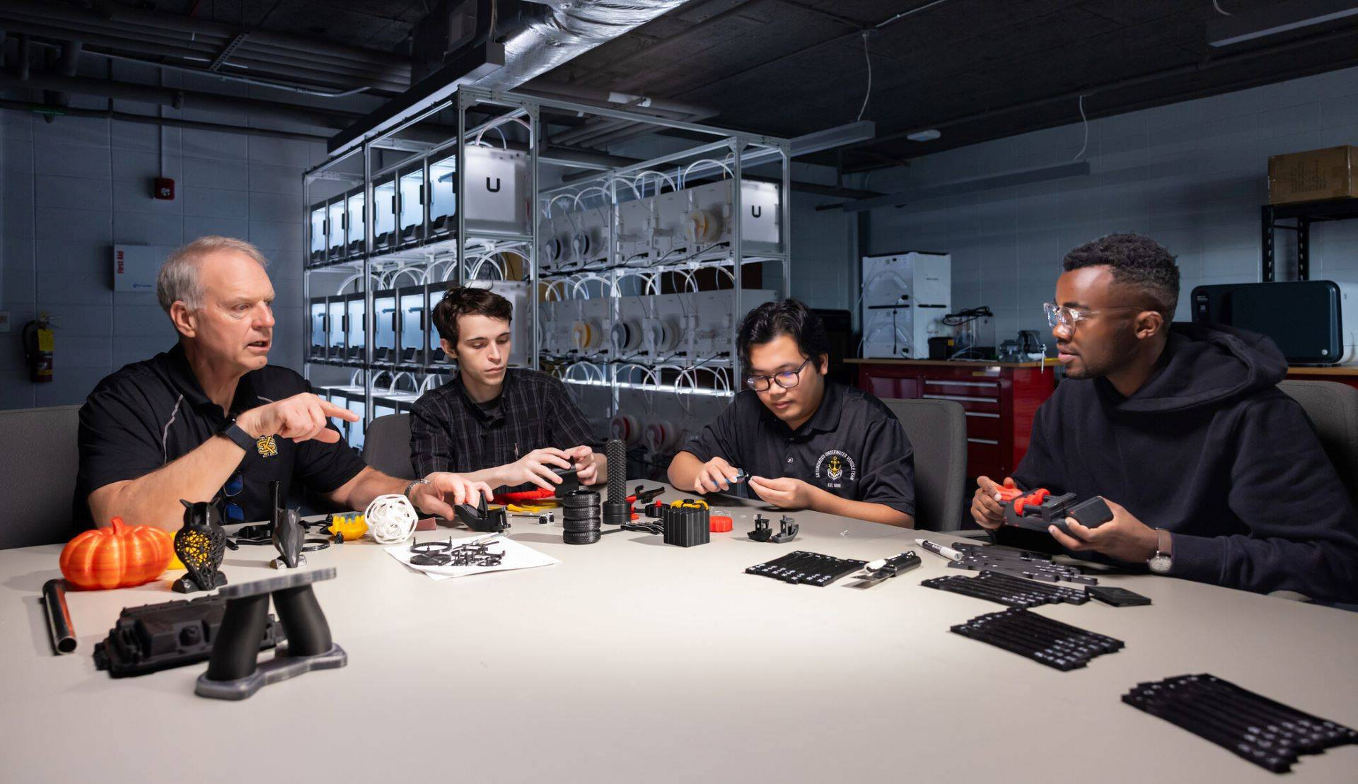 spceet team at table talking with robotics in 3d lab