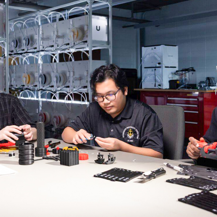 ksu male student at table working on robotic in lab