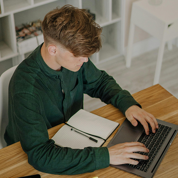 male student working at home on computer