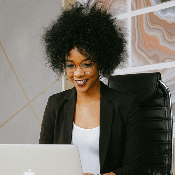 female student with glasses watching webinar on computer