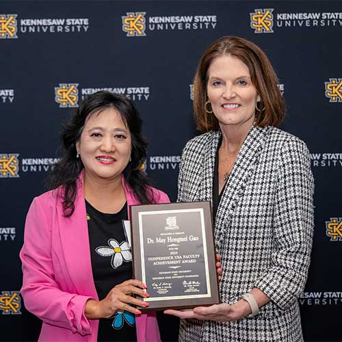 Kathy ‘Kat’ Schwaig giving a award to a faculty member.
