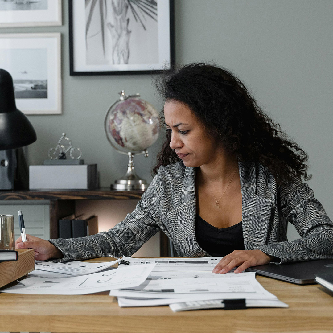 woman looking through papers on desk at work