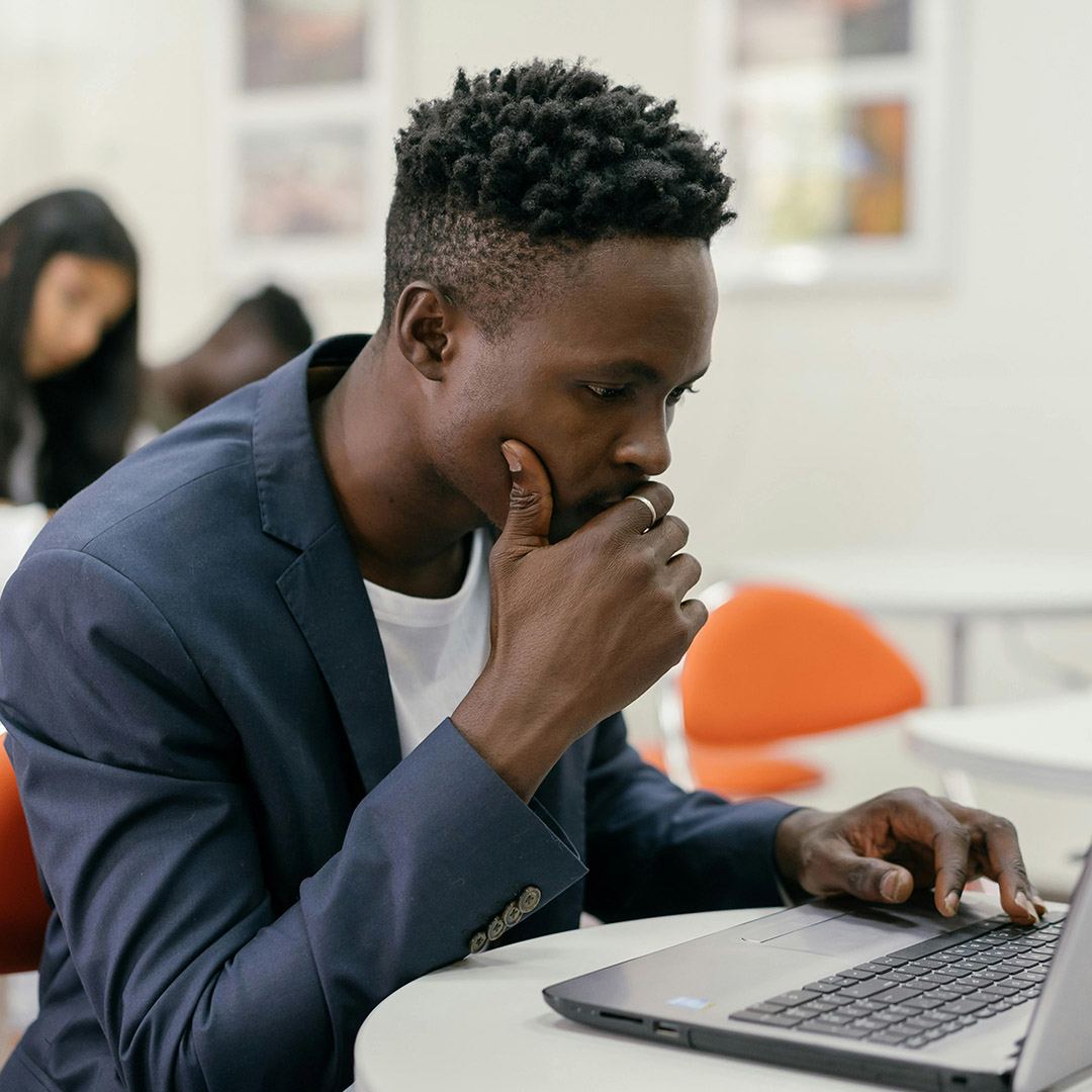 african american man in suit doing work on laptop