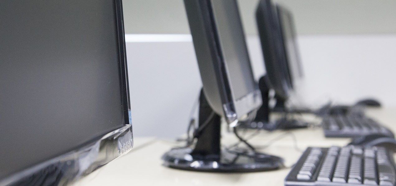 Computer monitors and keyboards sitting on a table