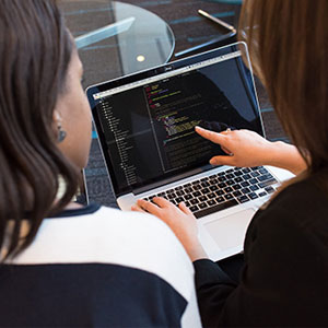 Two women using a laptop together, exploring the KSU Human Resources New Hire Onboarding Portal.