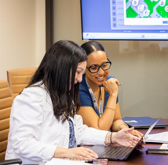 Two women looking at a laptop in an office setting