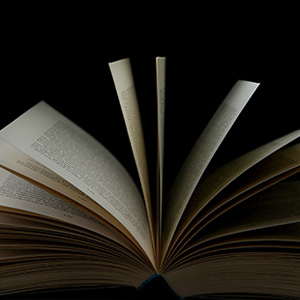 An open book on a black background, representing Faculty Affairs Resources for New Faculty.
