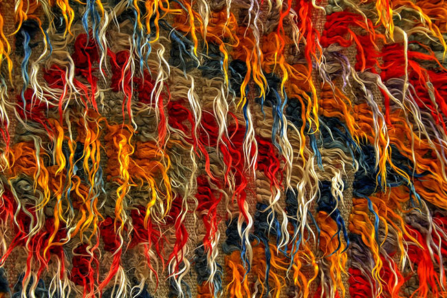 close-up view of a vibrant, multicolored rug showcasing intricate patterns and textures.