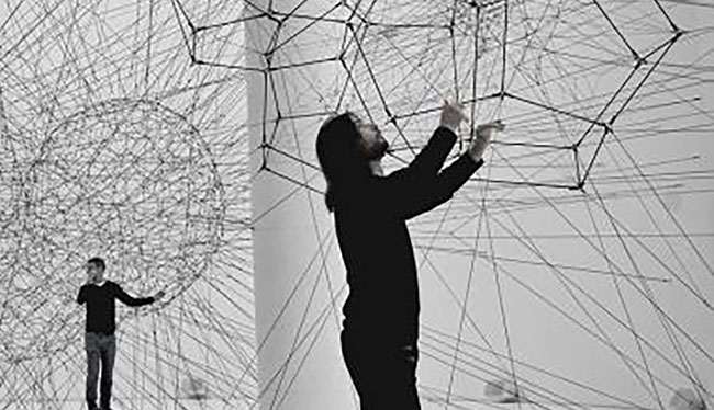 A large wire sculpture looms behind two individuals, illustrating concepts of Knowledge Organization and Enhanced Learning.