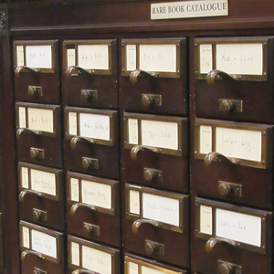 A large wooden cabinet with multiple drawers, used for storing teaching journals and educational materials.