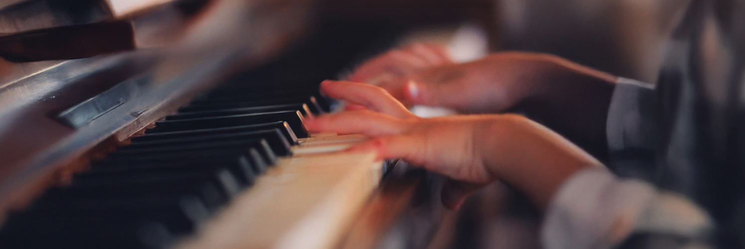 close up on hands playing on piano