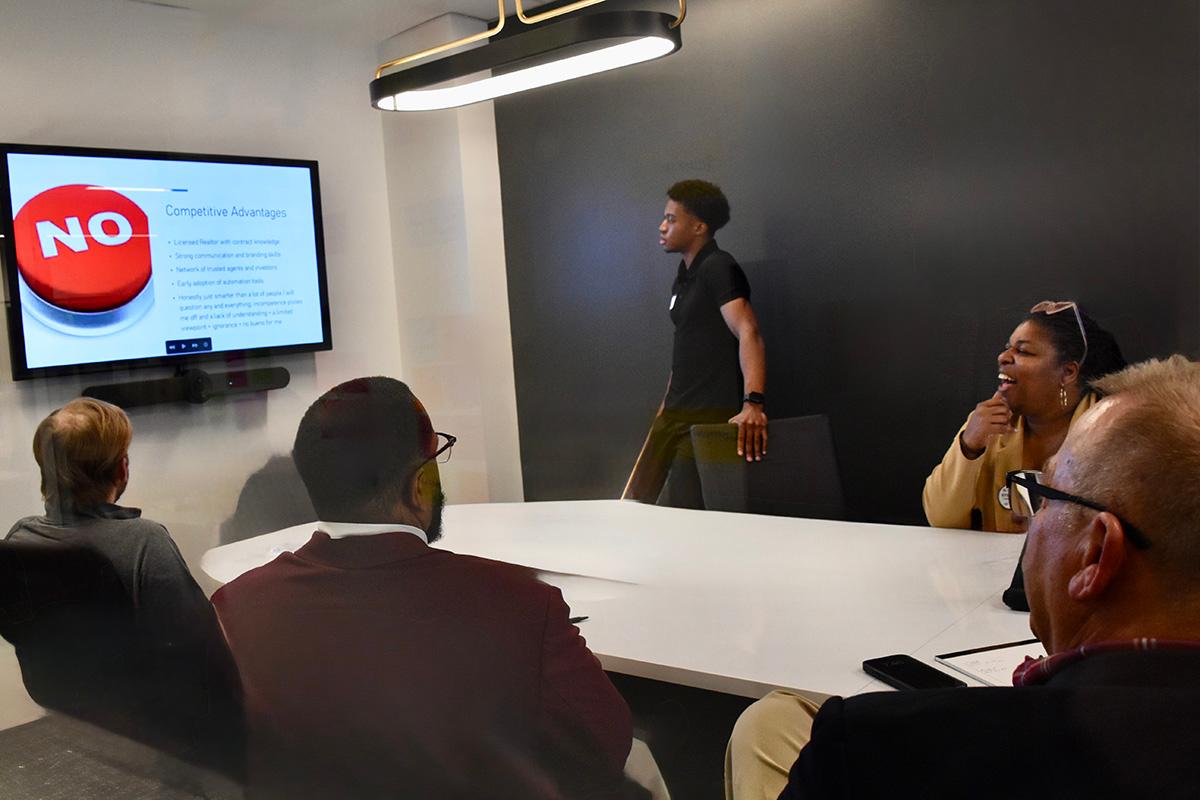 A STRIVE student gives a presentation in a board room  / 